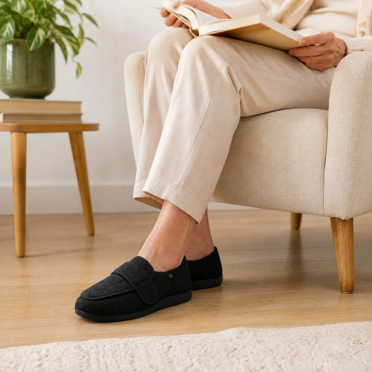 Femme portant les chaussons AMPELIO™ noirs dans un salon lumineux