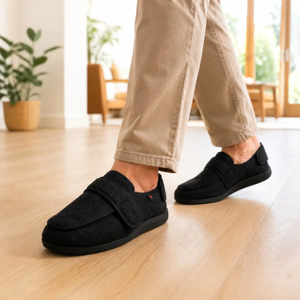 Homme marchant à la maison avec les chaussons AMPELIO™ noirs