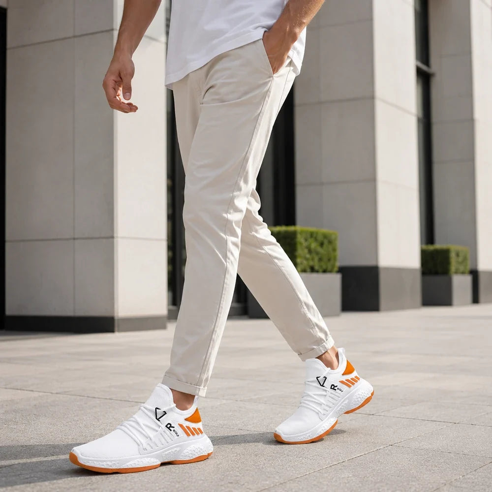 Homme portant des baskets Orthopodys, marque exploitée par AIIBORI (SASU), blanches et orange en mesh respirant