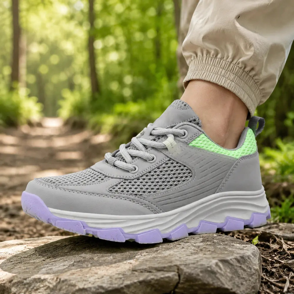 TREKOVA™ chaussure de randonnée légère homme avec semelle en caoutchouc posée sur une pierre sèche. Image